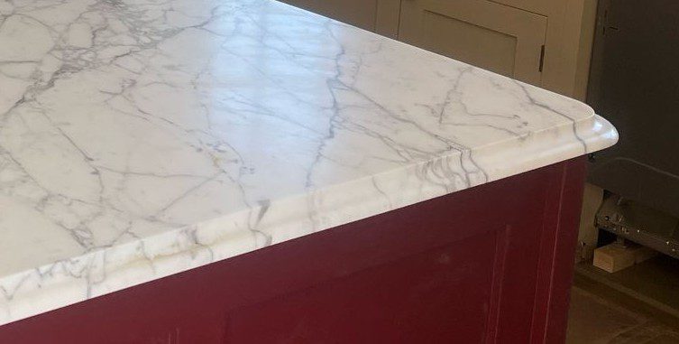Polished marble worktop with ogee edge detail installed in a luxury kitchen by The Granite House