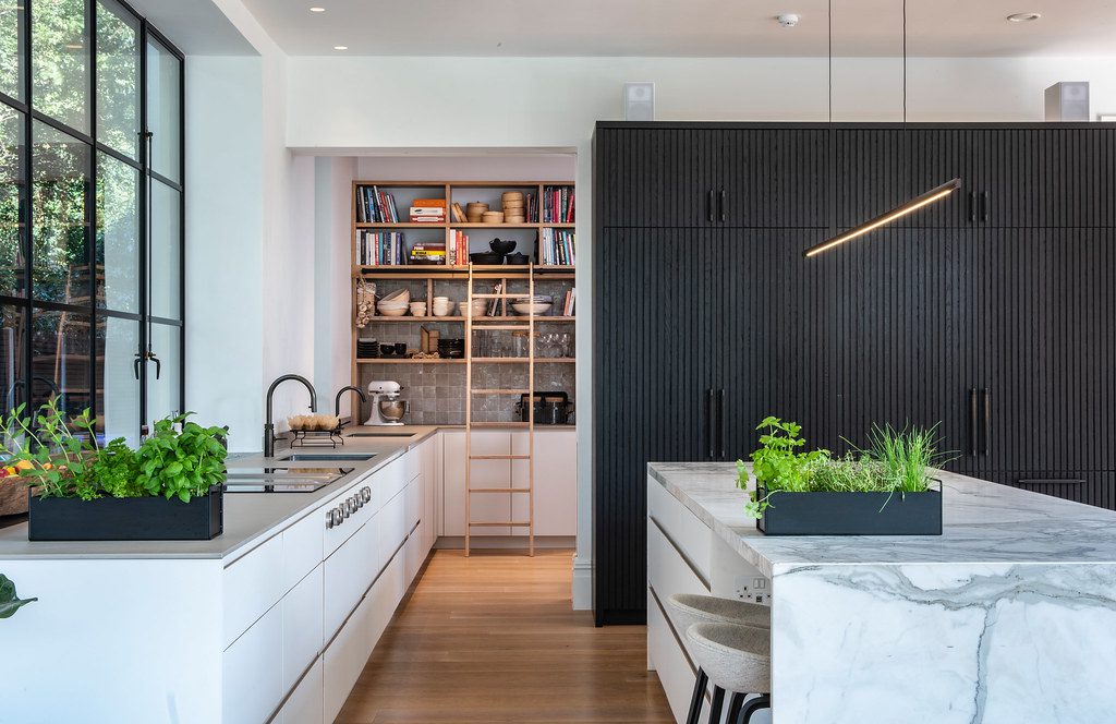 Modern kitchen featuring a grey sintered stone worktops and a marble effect island with contemporary cabinetry